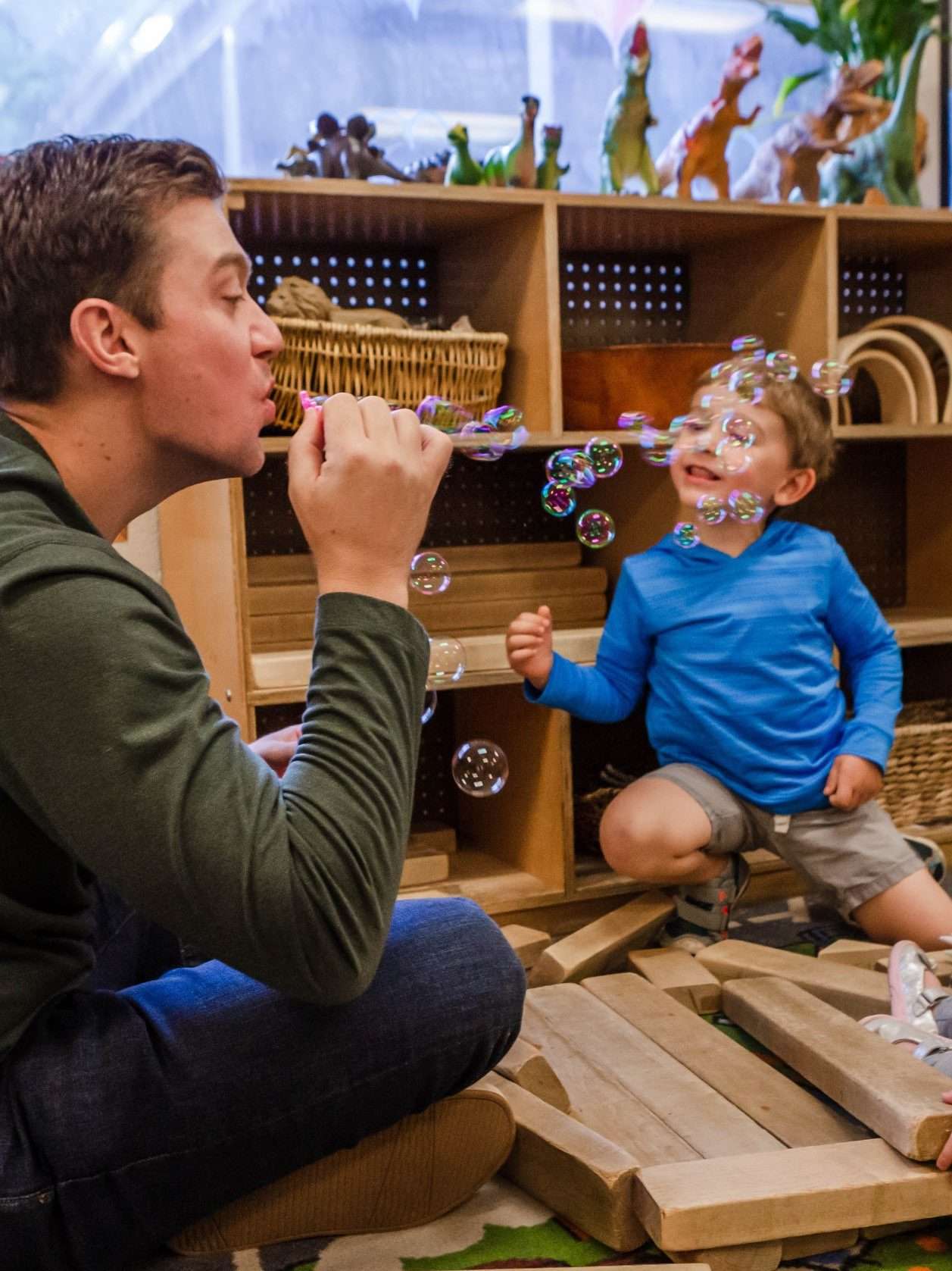 Man blowing bubbles with toddler